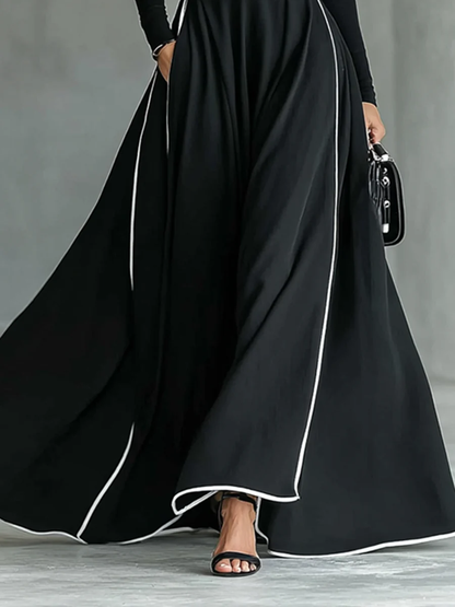 VESTIDO LARGO NEGRO CON COSTURAS BLANCAS, CUELLO ALTO Y MANGA LARGA