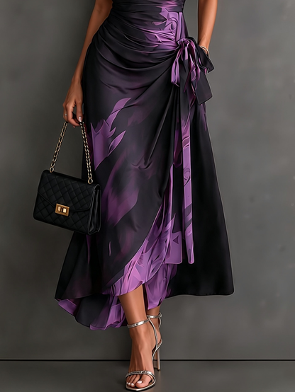 VESTIDO MIDI CRUZADO CON ESTAMPADO ABSTRACTO ROJO Y NEGRO, CUELLO CAMISERO CON ESCOTE EN V, MANGA CORTA, CINTURA ANUDADA Y BAJO ASIMÉTRICO CON VOLANTE