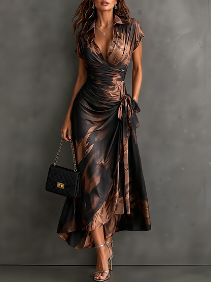 VESTIDO MIDI CRUZADO CON ESTAMPADO ABSTRACTO ROJO Y NEGRO, CUELLO CAMISERO CON ESCOTE EN V, MANGA CORTA, CINTURA ANUDADA Y BAJO ASIMÉTRICO CON VOLANTE