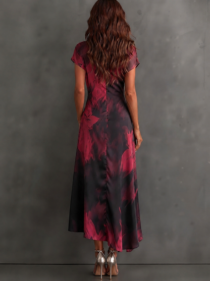 VESTIDO MIDI CRUZADO CON ESTAMPADO ABSTRACTO ROJO Y NEGRO, CUELLO CAMISERO CON ESCOTE EN V, MANGA CORTA, CINTURA ANUDADA Y BAJO ASIMÉTRICO CON VOLANTE