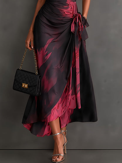 VESTIDO MIDI CRUZADO CON ESTAMPADO ABSTRACTO ROJO Y NEGRO, CUELLO CAMISERO CON ESCOTE EN V, MANGA CORTA, CINTURA ANUDADA Y BAJO ASIMÉTRICO CON VOLANTE